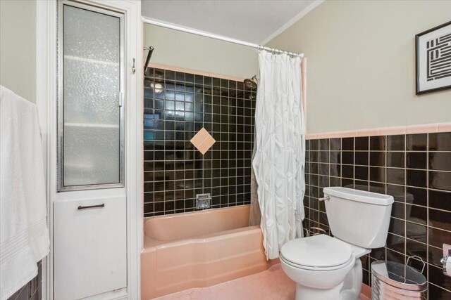 3808 Huaco Ln, Waco, TX 76710 - bathroom with toilet, shower / tub combo, tile walls, and wainscoting