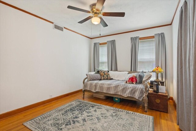 3808 Huaco Ln, Waco, TX 76710 - bedroom with baseboards, wood finished floors, crown molding, and ceiling fan