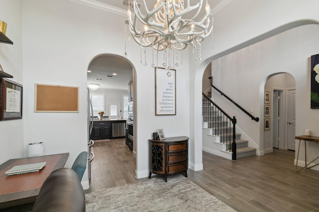 15236 Holly Bay Ct, Aledo, TX 76008 - foyer entrance featuring arched walkways, wood finished floors, a chandelier, a high ceiling, and stairs