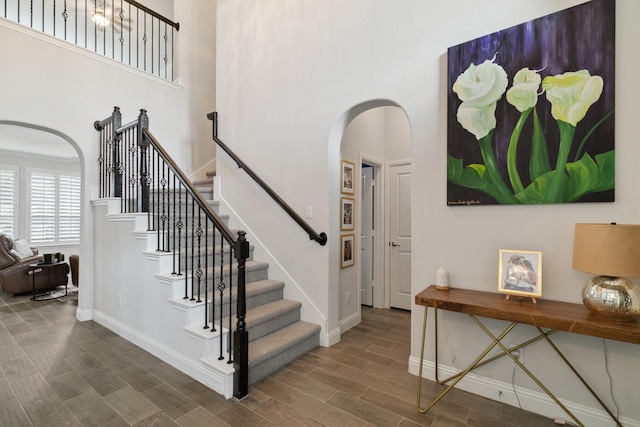 15236 Holly Bay Ct, Aledo, TX 76008 - stairs featuring arched walkways, a towering ceiling, and wood tiled floors