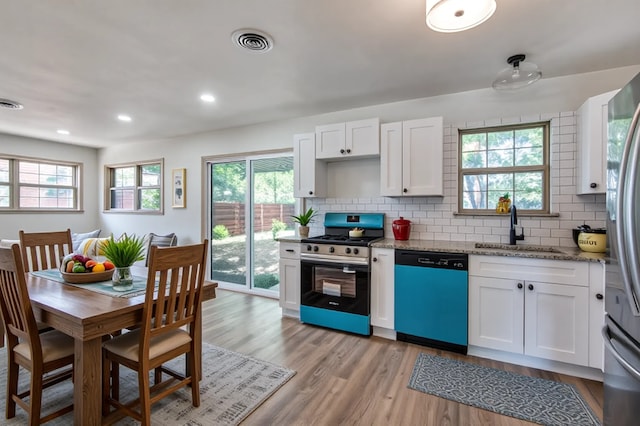2000 Bettibart St, Fort Worth, TX 76134 - kitchen with appliances with stainless steel finishes, backsplash, light wood finished floors, white cabinetry, and light stone counters