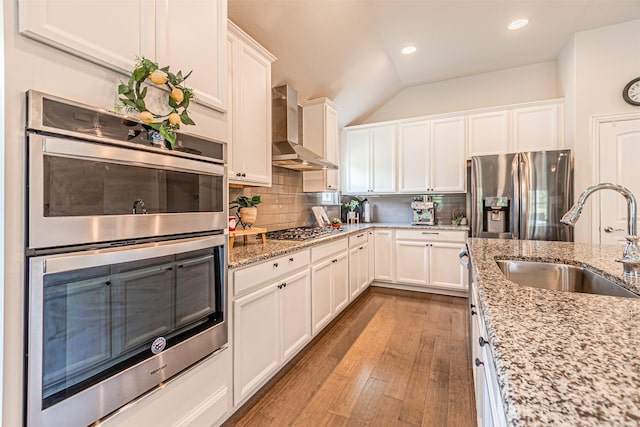 2923 Ash Ave, Melissa, TX 75454 - kitchen with appliances with stainless steel finishes, a sink, wall chimney range hood, vaulted ceiling, and wood finished floors