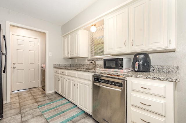 2517 Blanton St, Dallas, TX 75227 - kitchen with stainless steel dishwasher, black microwave, light stone counters, white cabinetry, and baseboards
