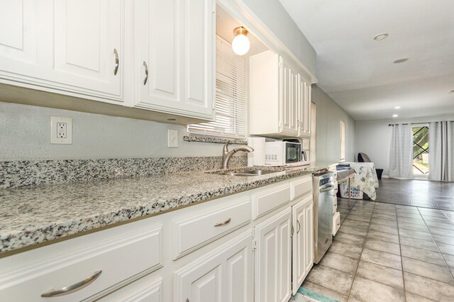 2517 Blanton St, Dallas, TX 75227 - kitchen featuring dishwasher, white cabinets, light stone counters, a sink, and recessed lighting