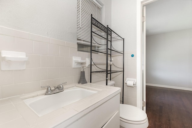 2517 Blanton St, Dallas, TX 75227 - half bath featuring toilet, tile walls, vanity, and wood finished floors