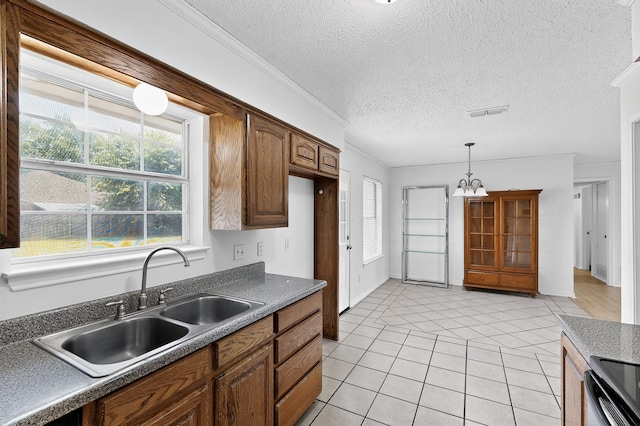 902 Church St, Sanger, TX 76266 - kitchen with light tile patterned flooring, plenty of natural light, a chandelier, dark countertops, and a textured ceiling