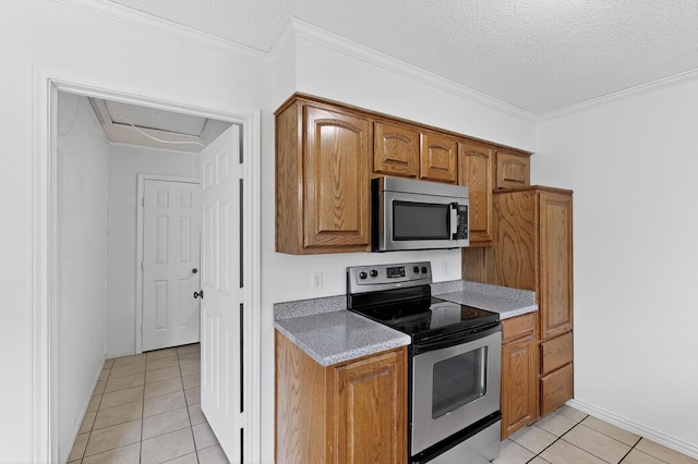 902 Church St, Sanger, TX 76266 - kitchen with appliances with stainless steel finishes, light tile patterned floors, brown cabinets, and ornamental molding