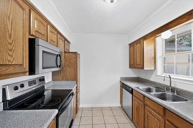 902 Church St, Sanger, TX 76266 - kitchen with appliances with stainless steel finishes, brown cabinets, a textured ceiling, ornamental molding, and light tile patterned flooring