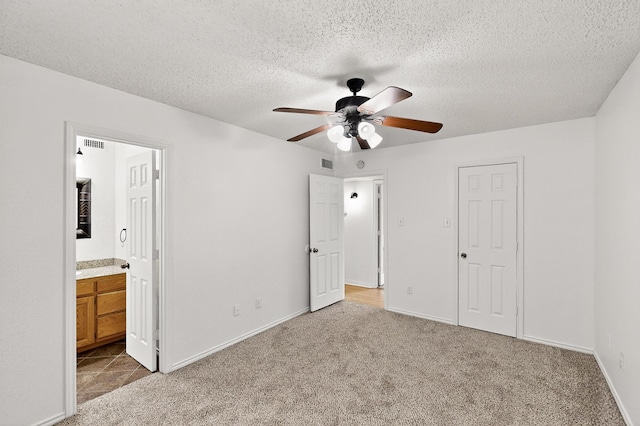 902 Church St, Sanger, TX 76266 - unfurnished bedroom featuring carpet floors, a textured ceiling, ensuite bathroom, and ceiling fan