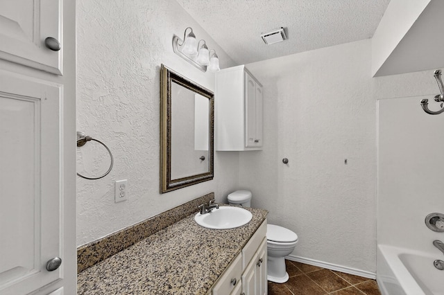 902 Church St, Sanger, TX 76266 - bathroom featuring vanity, a textured ceiling, tile patterned flooring, a textured wall, and bathtub / shower combination