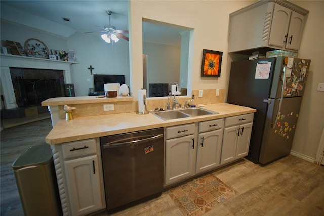 618 Matador Dr, Oak Point, TX 75068 - kitchen featuring stainless steel appliances, a sink, a ceiling fan, ornamental molding, and light wood-style flooring