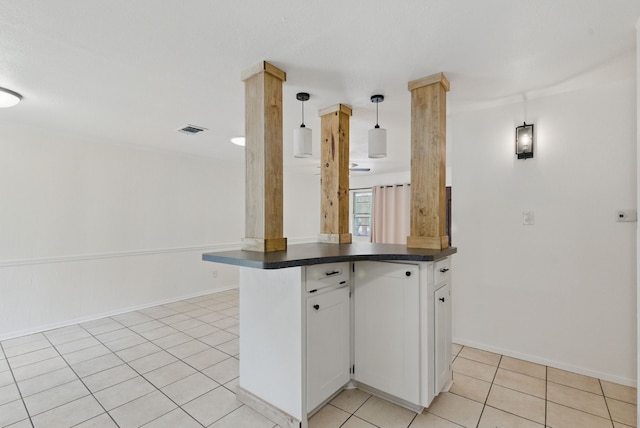 805 S Rusk St, Weatherford, TX 76086 - kitchen featuring dark countertops, light tile patterned floors, white cabinets, baseboards, and pendant lighting