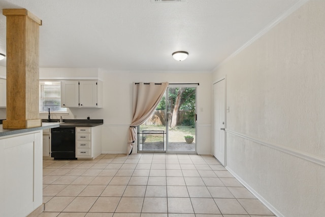 805 S Rusk St, Weatherford, TX 76086 - kitchen with dishwasher, white cabinetry, crown molding, light tile patterned floors, and baseboards