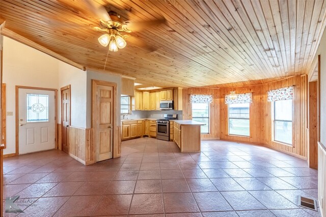 3017 County Road 154, Tuscola, TX 79562 - kitchen featuring appliances with stainless steel finishes, light brown cabinetry, ceiling fan, light countertops, and wood walls