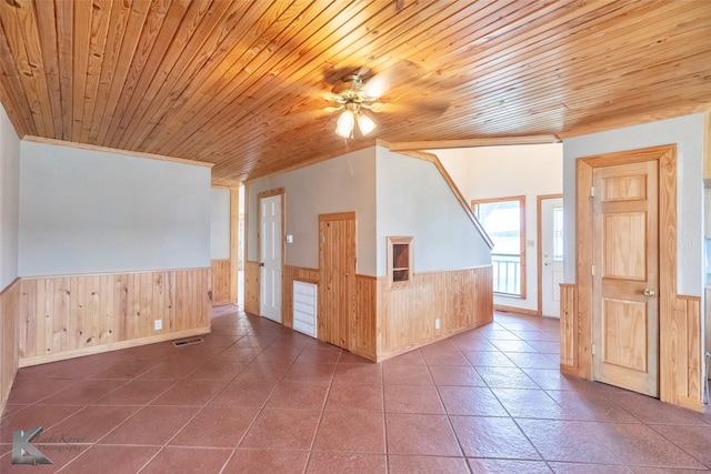 3017 County Road 154, Tuscola, TX 79562 - empty room featuring a wainscoted wall, wooden walls, tile patterned floors, and ceiling fan