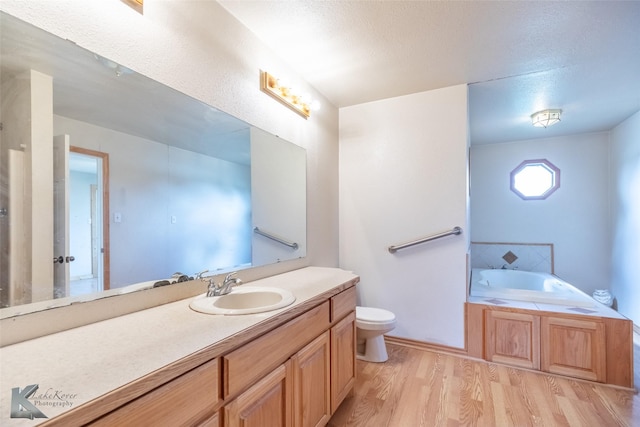 3017 County Road 154, Tuscola, TX 79562 - full bath with vanity, a bath, toilet, wood finished floors, and a textured ceiling