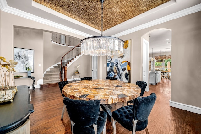 7363 Calla Lilly Ln, Frisco, TX 75034 - dining area featuring a tray ceiling, stairs, arched walkways, crown molding, and wood finished floors