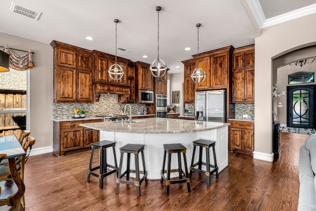 7363 Calla Lilly Ln, Frisco, TX 75034 - kitchen with stainless steel appliances, a sink, a large island with sink, dark wood-type flooring, and recessed lighting