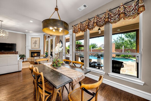 7363 Calla Lilly Ln, Frisco, TX 75034 - dining room featuring healthy amount of natural light, dark wood-type flooring, baseboards, recessed lighting, and a glass covered fireplace