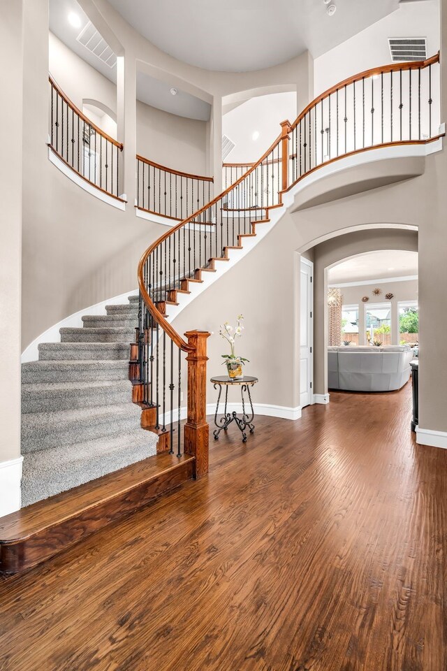 7363 Calla Lilly Ln, Frisco, TX 75034 - stairway with arched walkways, wood finished floors, baseboards, and a towering ceiling
