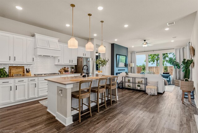 752 Fletcher Dr, Fate, TX 75087 - kitchen featuring premium range hood, open floor plan, a center island with sink, a ceiling fan, and light countertops