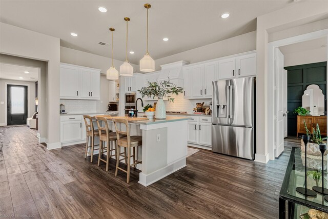 752 Fletcher Dr, Fate, TX 75087 - kitchen featuring appliances with stainless steel finishes, a kitchen island with sink, decorative backsplash, light countertops, and recessed lighting