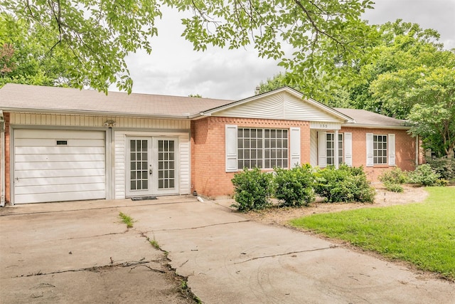133 SE Newton Dr, Burleson, TX 76028 - ranch-style house featuring brick siding, an attached garage, concrete driveway, and french doors