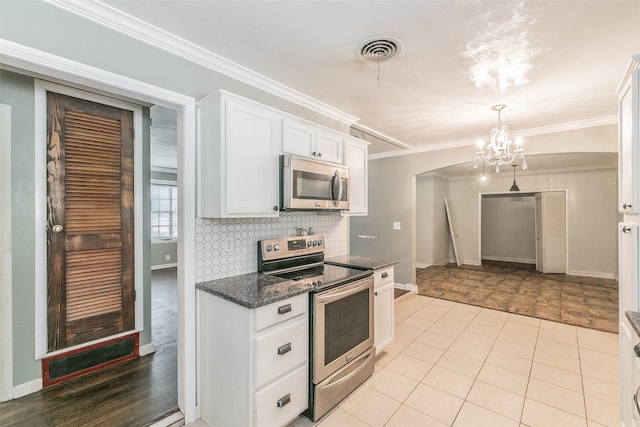 133 SE Newton Dr, Burleson, TX 76028 - kitchen with stainless steel appliances, white cabinetry, a chandelier, baseboards, and crown molding