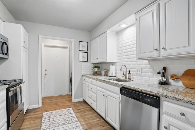105 Yorkshire Ct, Euless, TX 76040 - kitchen featuring stainless steel appliances, a sink, white cabinetry, and decorative backsplash