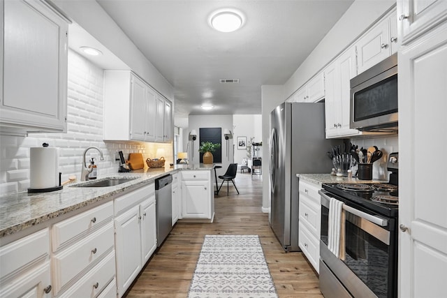 105 Yorkshire Ct, Euless, TX 76040 - kitchen with stainless steel appliances, a sink, white cabinets, and decorative backsplash