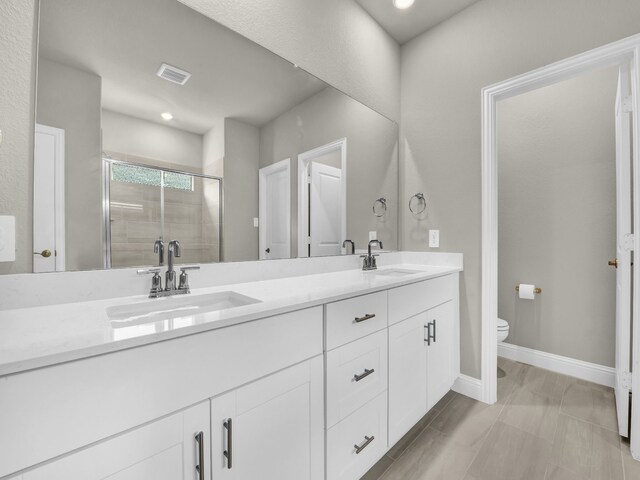 9100 Cacti Ct, Fort Worth, TX 76036 - bathroom featuring double vanity, toilet, a shower stall, baseboards, and recessed lighting