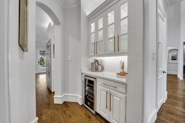 7209 Braemar Ter, Colleyville, TX 76034 - indoor dry bar with wine cooler, arched walkways, dark wood finished floors, crown molding, and baseboards