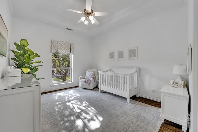 7209 Braemar Ter, Colleyville, TX 76034 - bedroom featuring ornamental molding, a raised ceiling, wood finished floors, a crib, and a ceiling fan
