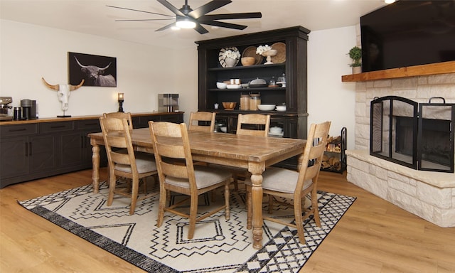 13417 Hickory Creek Dr, Haslet, TX 76052 - dining space with light wood finished floors, ceiling fan, and a stone fireplace
