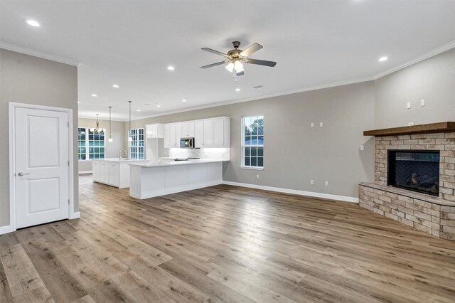 5128 Country Club Dr, Granbury, TX 76049 - unfurnished living room featuring crown molding, light wood finished floors, ceiling fan, a brick fireplace, and baseboards