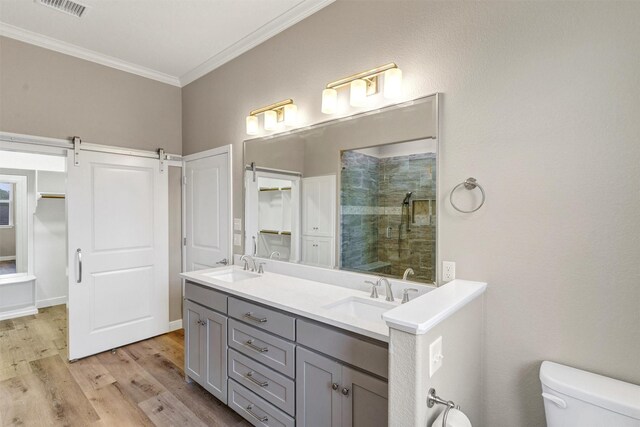 5128 Country Club Dr, Granbury, TX 76049 - bathroom featuring ornamental molding, a tile shower, toilet, double vanity, and wood finished floors