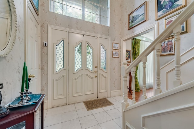 1412 Hyde Park Ln, Arlington, TX 76015 - entryway featuring a high ceiling, healthy amount of natural light, light tile patterned flooring, stairway, and wallpapered walls