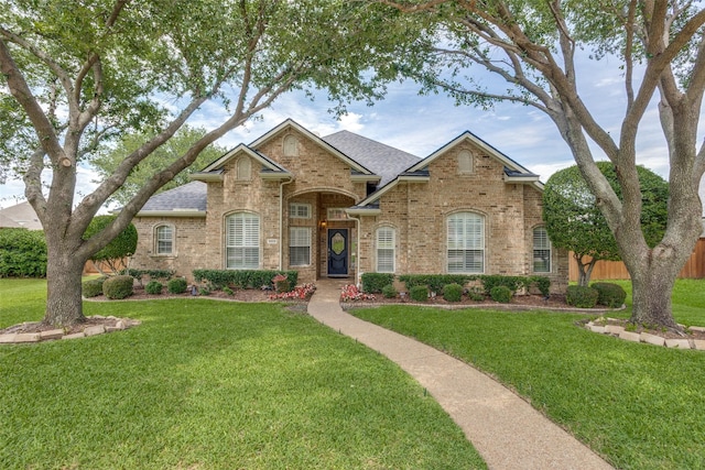 9808 Capilano Dr, Plano, TX 75025 - view of front of home featuring brick siding, a front yard, and a shingled roof