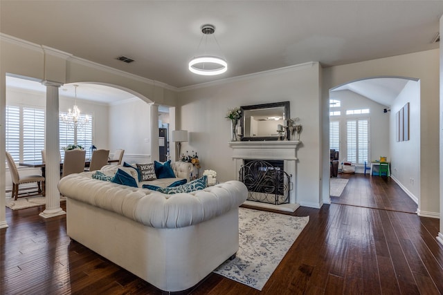 9808 Capilano Dr, Plano, TX 75025 - living room featuring arched walkways, healthy amount of natural light, ornate columns, a fireplace with raised hearth, and ornamental molding