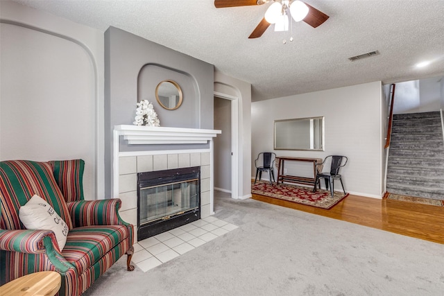 1017 Lake Trail Dr, Little Elm, TX 75068 - living area featuring stairs, carpet, a fireplace, a ceiling fan, and a textured ceiling