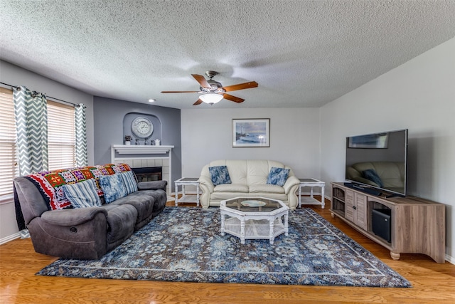 1017 Lake Trail Dr, Little Elm, TX 75068 - living area with wood finished floors, baseboards, a fireplace, and a textured ceiling