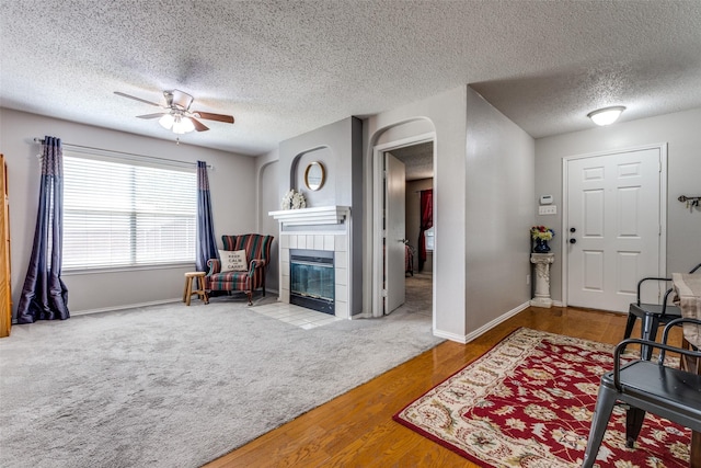 1017 Lake Trail Dr, Little Elm, TX 75068 - living room featuring ceiling fan, a fireplace, a textured ceiling, wood finished floors, and baseboards