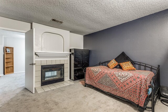 1017 Lake Trail Dr, Little Elm, TX 75068 - bedroom featuring carpet, a tiled fireplace, a textured ceiling, and a textured wall