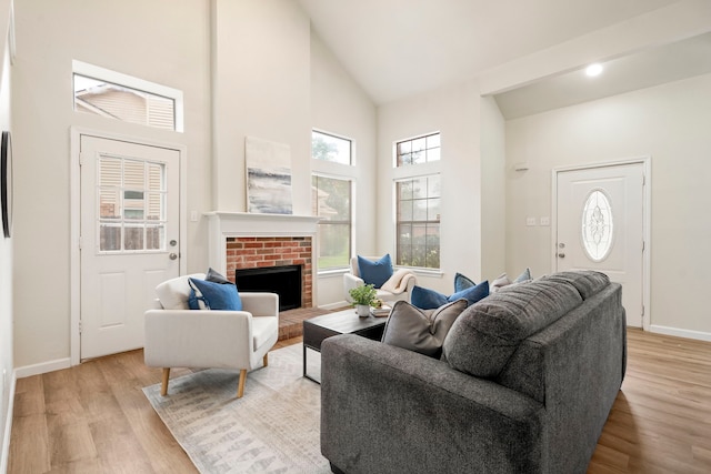 808 Brockden Dr, Mesquite, TX 75149 - living room featuring high vaulted ceiling, light wood-style floors, a brick fireplace, and baseboards