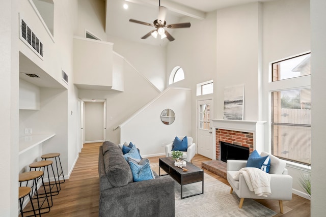 808 Brockden Dr, Mesquite, TX 75149 - living area with a high ceiling, wood finished floors, stairs, beam ceiling, and a brick fireplace