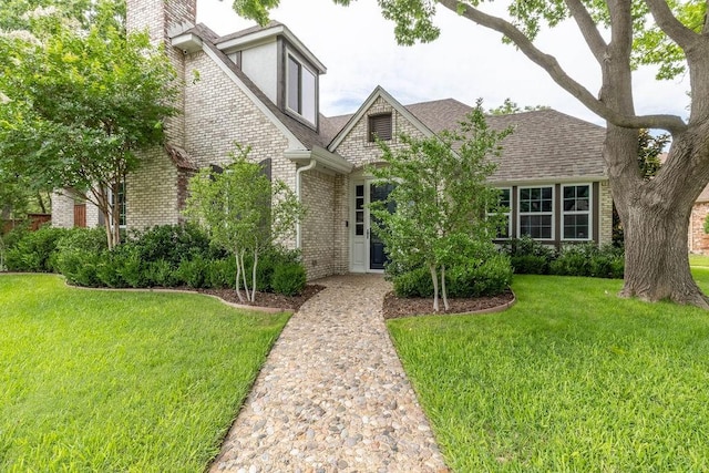 1401 Chesapeake Dr, Plano, TX 75093 - tudor-style house with brick siding, a front lawn, roof with shingles, and a chimney