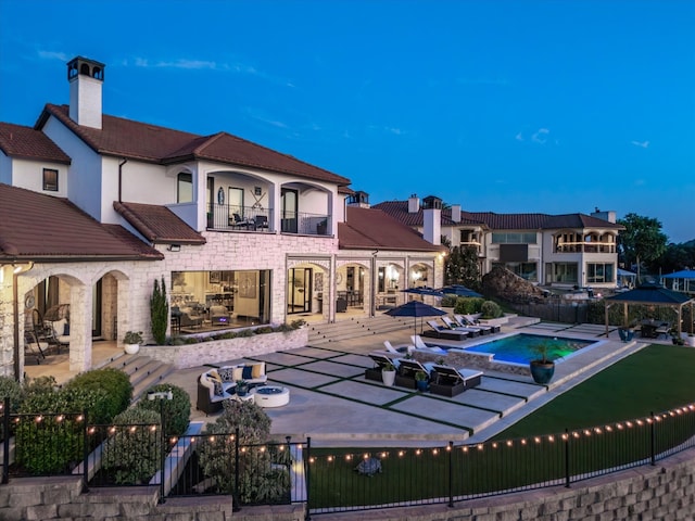 12633 Lakeview Ct, Fort Worth, TX 76179 - rear view of property with a balcony, a patio, a fenced backyard, stone siding, and an in-ground hot tub