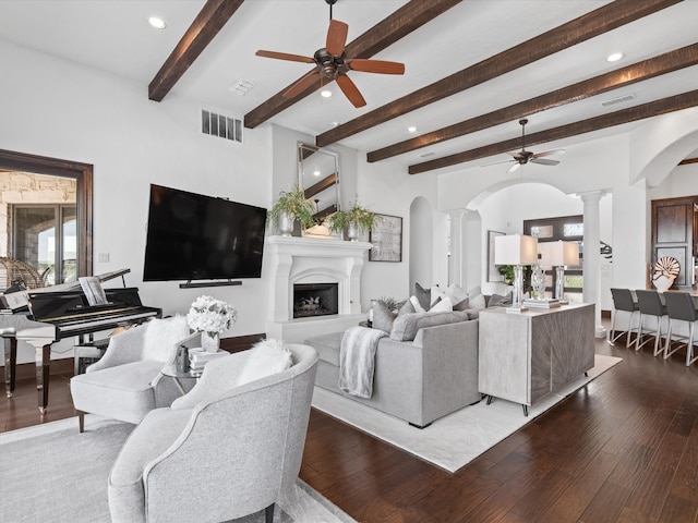 12633 Lakeview Ct, Fort Worth, TX 76179 - living room featuring ornate columns, a ceiling fan, arched walkways, dark wood-style floors, and beamed ceiling