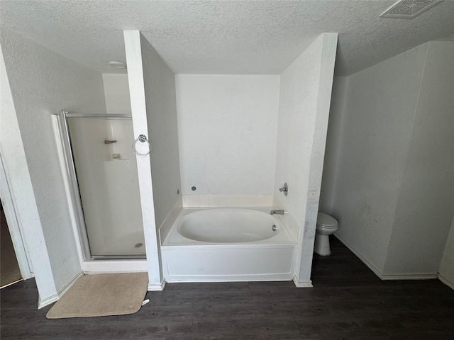 4331 Stetson Run, San Antonio, TX 78223 - full bathroom with wood finished floors, a bath, toilet, a shower stall, and a textured ceiling