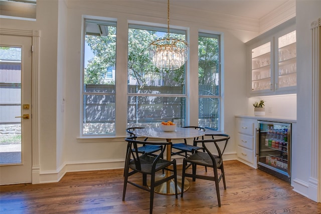 1360 Bent Trail Cir, Southlake, TX 76092 - dining room featuring wine cooler, ornamental molding, wood finished floors, a chandelier, and a dry bar